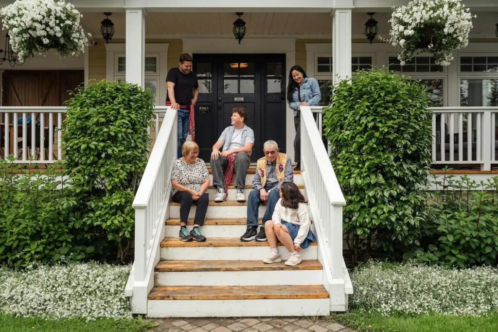 Family sitting together on the front porch steps of their home