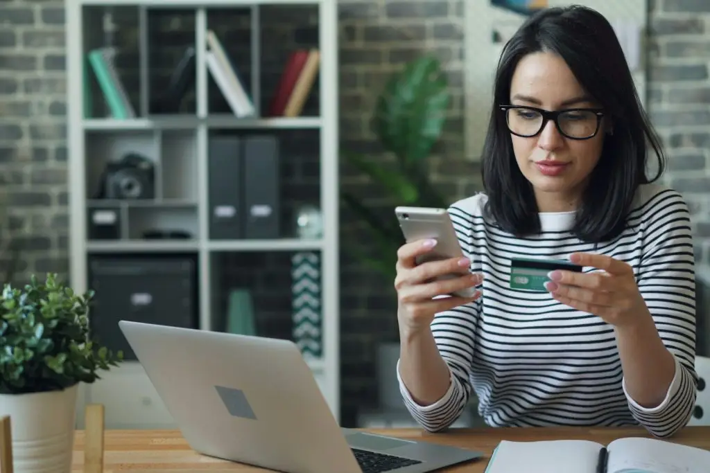 Woman sitting at a table checking her phone